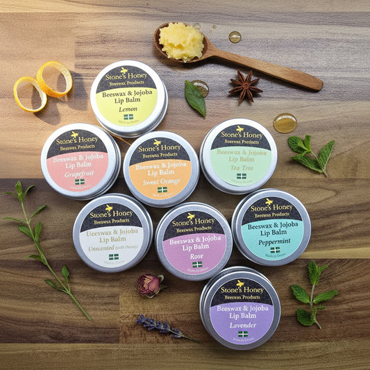 Collection of Stone's Honey lip balm tins on a wooden surface